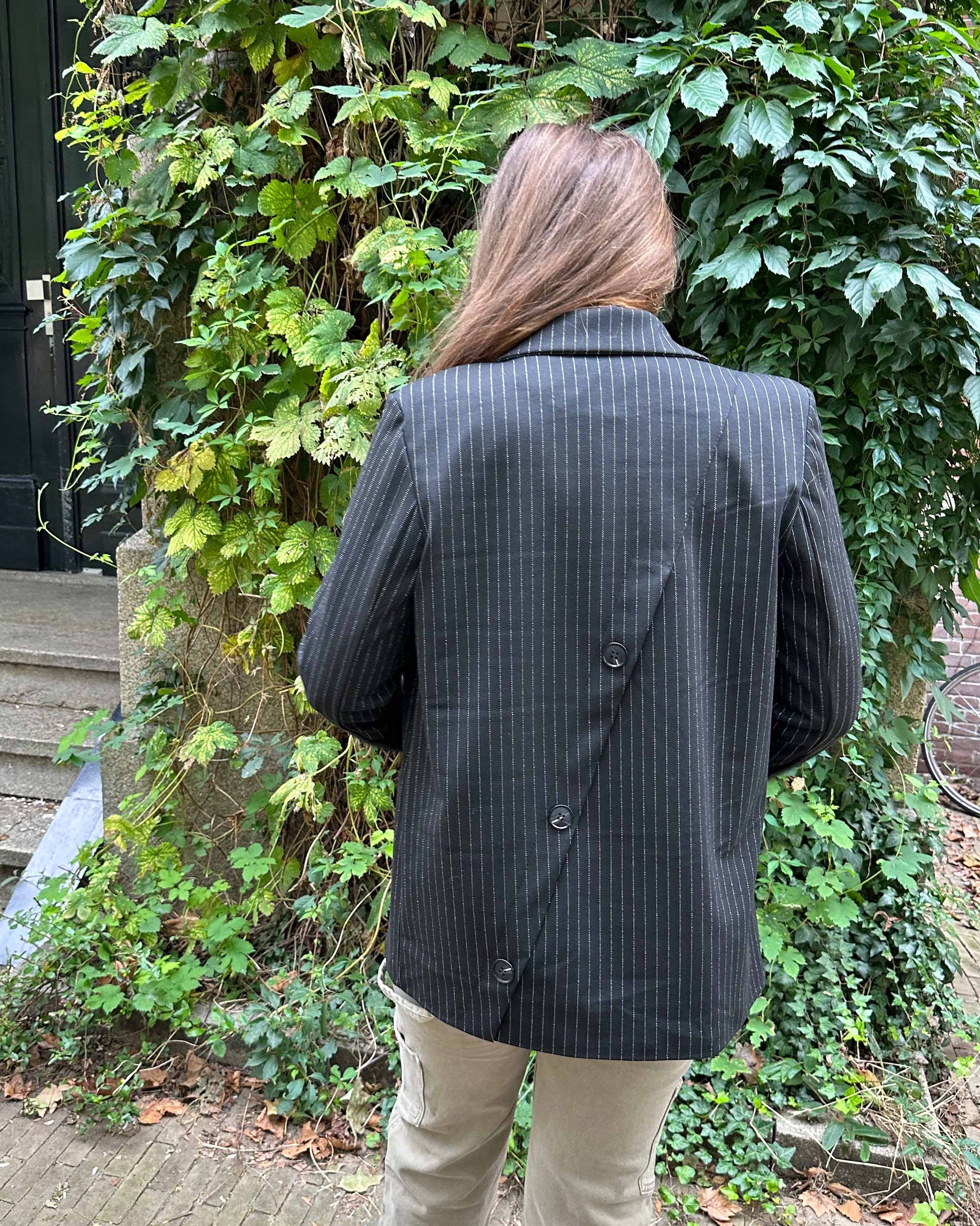 Achterkant zwarte dames blazer/cobert met zilver streepje